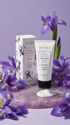 Crème de Soin DermoLift Green Spa avec son étui, entourée de fleurs d’iris